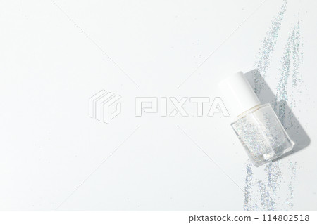 White nail polish with glitter on a white background White nail polish with glitter on a white background 114802518