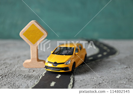 Yellow car on the road with a sign. 114802545