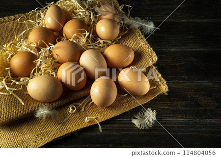 A pile of chicken eggs with straw and feathers. Eggs are collected to make a healthy breakfast or dinner. Advertising space A pile of chicken eggs with straw and feathers. Eggs are collected to make a healthy breakfast or dinner. Advertising space 114804056