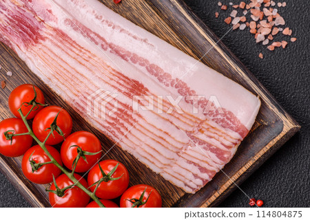 Delicious bacon in the form of slices with salt, spices and herbs Delicious bacon in the form of slices with salt, spices and herbs 114804875