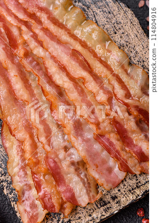 Delicious bacon in the form of slices with salt, spices and herbs Delicious bacon in the form of slices with salt, spices and herbs 114804916