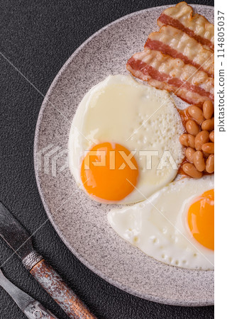 English breakfast with fried eggs, bacon, beans, tomatoes, spices and herbs English breakfast with fried eggs, bacon, beans, tomatoes, spices and herbs 114805037