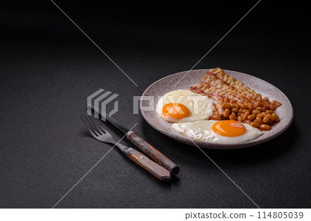 English breakfast with fried eggs, bacon, beans, tomatoes, spices and herbs English breakfast with fried eggs, bacon, beans, tomatoes, spices and herbs 114805039