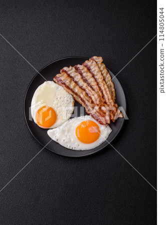 English breakfast with fried eggs, bacon, beans, tomatoes, spices and herbs English breakfast with fried eggs, bacon, beans, tomatoes, spices and herbs 114805044