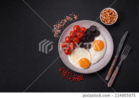 English breakfast with fried eggs, bacon, beans, tomatoes, spices and herbs English breakfast with fried eggs, bacon, beans, tomatoes, spices and herbs 114805075