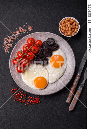 English breakfast with fried eggs, bacon, beans, tomatoes, spices and herbs English breakfast with fried eggs, bacon, beans, tomatoes, spices and herbs 114805078