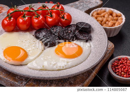 English breakfast with fried eggs, bacon, beans, tomatoes, spices and herbs 114805087