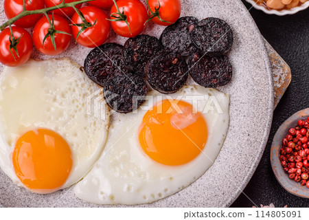 English breakfast with fried eggs, bacon, beans, tomatoes, spices and herbs 114805091