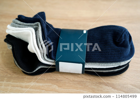 Package of multi-colored men's socks short, woven socks packaged, on a wooden floor Package of multi-colored men's socks short, woven socks packaged, on a wooden floor 114805499