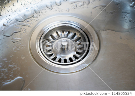 Stainless steel sink and water drain in a modern kitchen, water flow in the kitchen sink Stainless steel sink and water drain in a modern kitchen, water flow in the kitchen sink 114805524