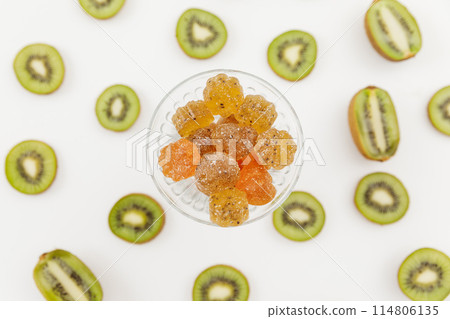 Tasty candied fruit jelly with kiwi fruits on white. Flat lay, top view. Tasty candied fruit jelly with kiwi fruits on white. Flat lay, top view. 114806135