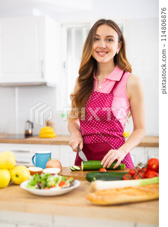Smiling woman cooking dinner at home 114806876
