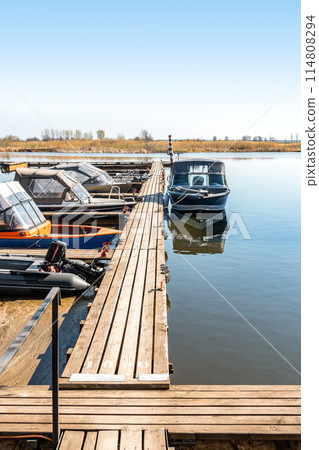 Fishing boats moored at wooden pontoon pier in morning Fishing boats moored at wooden pontoon pier in morning 114808294