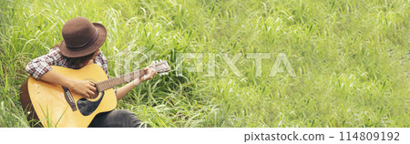 Banner women playing acoustic guitar outdoor in green park. Woman playing acoustic guitar music instrument at home. Wide Asian musician girl lifestyle in green nature. Happy guitarist with copy space Banner women playing acoustic guitar outdoor in green park. Woman playing acoustic guitar music instrument at home. Wide Asian musician girl lifestyle in green nature. Happy guitarist with copy space 114809192