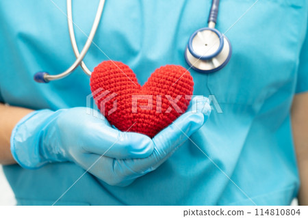 Doctor holding a red heart in hospital ward, healthy strong medical. 114810804