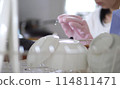 A woman washing dishes, a woman washing dishes, a woman taking out dishes 114811471