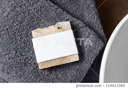 Soap bar with blank label on grey towels near vessel sink on wood in bathroom, mockup Soap bar with blank label on grey towels near vessel sink on wood in bathroom, mockup 114811560