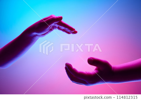 Kids hands gesturing against gradient blue purple background in neon light. Two children cooperating Kids hands gesturing against gradient blue purple background in neon light. Two children cooperating 114812315