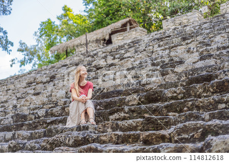 Woman tourist at Coba, Mexico. Ancient mayan city in Mexico. Coba is an archaeological area and a famous landmark of Yucatan Peninsula. Cloudy sky over a pyramid in Mexico Woman tourist at Coba, Mexico. Ancient mayan city in Mexico. Coba is an archaeological area and a famous landmark of Yucatan Peninsula. Cloudy sky over a pyramid in Mexico 114812618