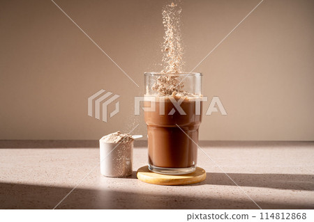 Protein shake and chocolate protein powder in a scoop, food supplement 114812868