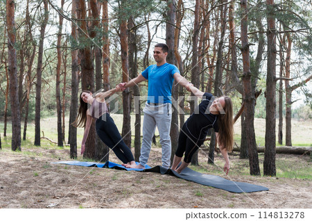 Three people standing in an elaborate acro yoga pose. Three people standing in an elaborate acro yoga pose. 114813278