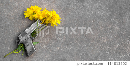Gun and yellow flowers on asphalt. concept of memory, fragility of peace, no war, stop war, world peace, pacifism. Banner, copy space, text space, template, layout, mockup 114813302
