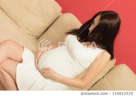 pregnant woman relaxing on sofa pregnant woman relaxing on sofa 114813329