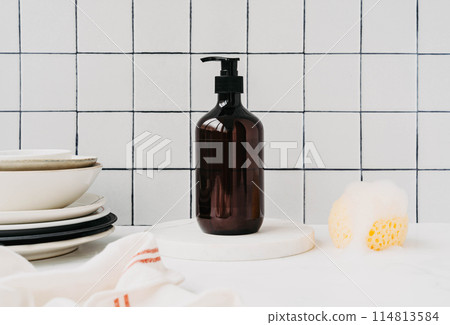 Bottle with dish detergent on marble podium with clean plates and sponge with foam Bottle with dish detergent on marble podium with clean plates and sponge with foam 114813584