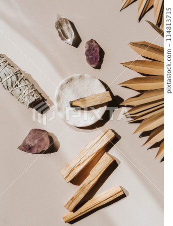 White sage and Palo Santo and amethyst and quartz crystals on a light beige background. 114813715
