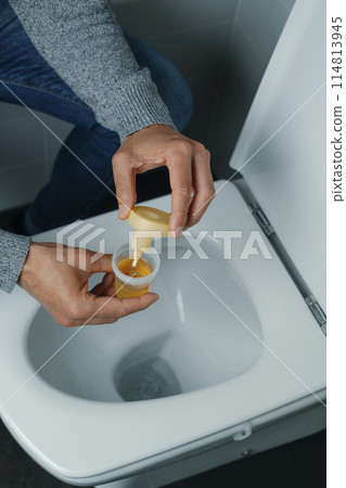 man in the bathroom collecting a urine sample man in the bathroom collecting a urine sample 114813945