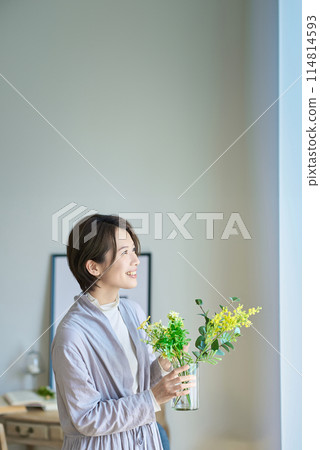 Woman holding a vase of flowers Woman holding a vase of flowers 114814593