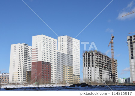 Construction of new residential high-rise buildings. Against the background of a yellow sunset sky. Construction of new residential high-rise buildings. Against the background of a yellow sunset sky. 114815917