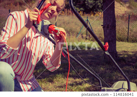 Woman mowing green grass Woman mowing green grass 114816041