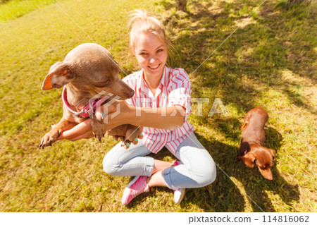 Woman playing pinscher ratter dog outside Woman playing pinscher ratter dog outside 114816062