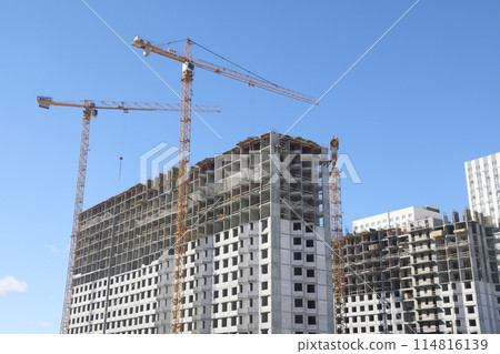 Construction of new residential high-rise buildings. Against the background of a yellow sunset sky. 114816139