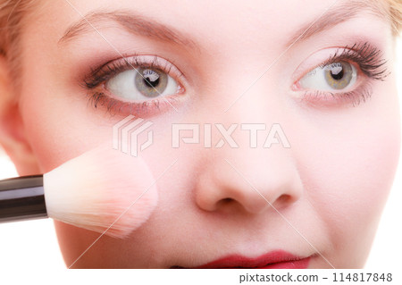 Part of woman face applying rouge blusher makeup detail. 114817848