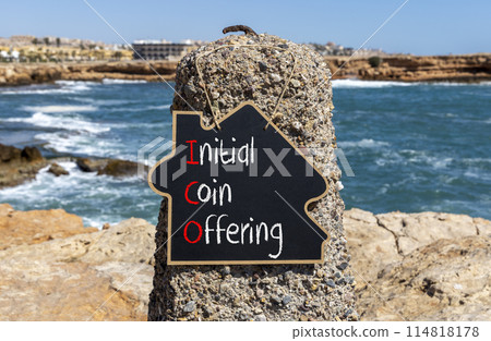 ICO initial coin offering symbol. Concept words ICO initial coin offering on beautiful yellow blackboard. Beautiful stone blue sky background. Business ICO initial coin offering concept. Copy space. 114818178