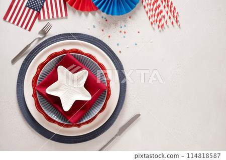 Patriotic table setting with american flag and decoration in national flag colors on white background. Independence Day. Happy Memorial Day. View from above. Copy space. 114818587