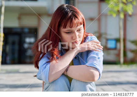 Upset sad unhappy young female sitting outdoor on steps Upset sad unhappy young female sitting outdoor on steps 114818777