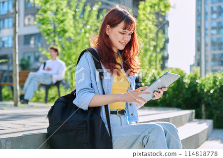 Young female college student using digital tablet outdoor Young female college student using digital tablet outdoor 114818778