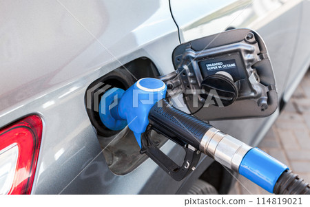 Passenger car is refueled at a gas station. Gasoline pump gun to release fuel 114819021