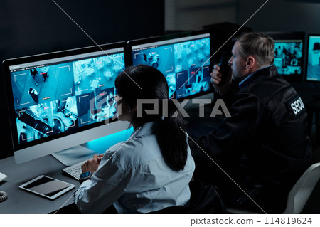 Officers in front of computer monitors 114819624