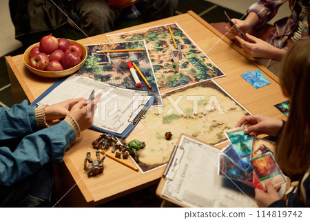 Kids looking through board game cards Kids looking through board game cards 114819742