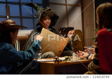 Witch boy with open book of rules Witch boy with open book of rules 114819749