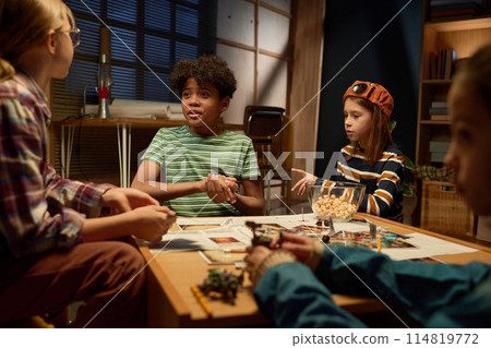 Boy chatting to friend during board game Boy chatting to friend during board game 114819772