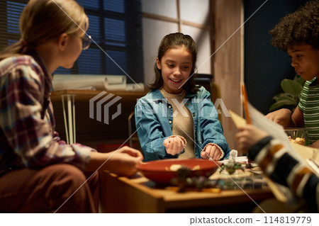Smiling youthful girl with dice in hand 114819779