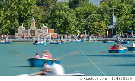 Tourists on boats at lake near Monument to Alfonso XII timelapse in the Park of the Pleasant Retreat in Madrid, Spain 114820139