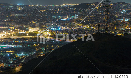 Barcelona and Badalona skyline with roofs of houses and sea on the horizon night timelapse 114820513
