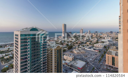 Cityscape with towers in Ajman from rooftop day to night timelapse. United Arab Emirates. Cityscape with towers in Ajman from rooftop day to night timelapse. United Arab Emirates. 114820584