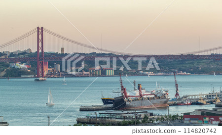 Skyline over Lisbon commercial port day to night timelapse, 25th April Bridge, containers on pier with freight cranes Skyline over Lisbon commercial port day to night timelapse, 25th April Bridge, containers on pier with freight cranes 114820742